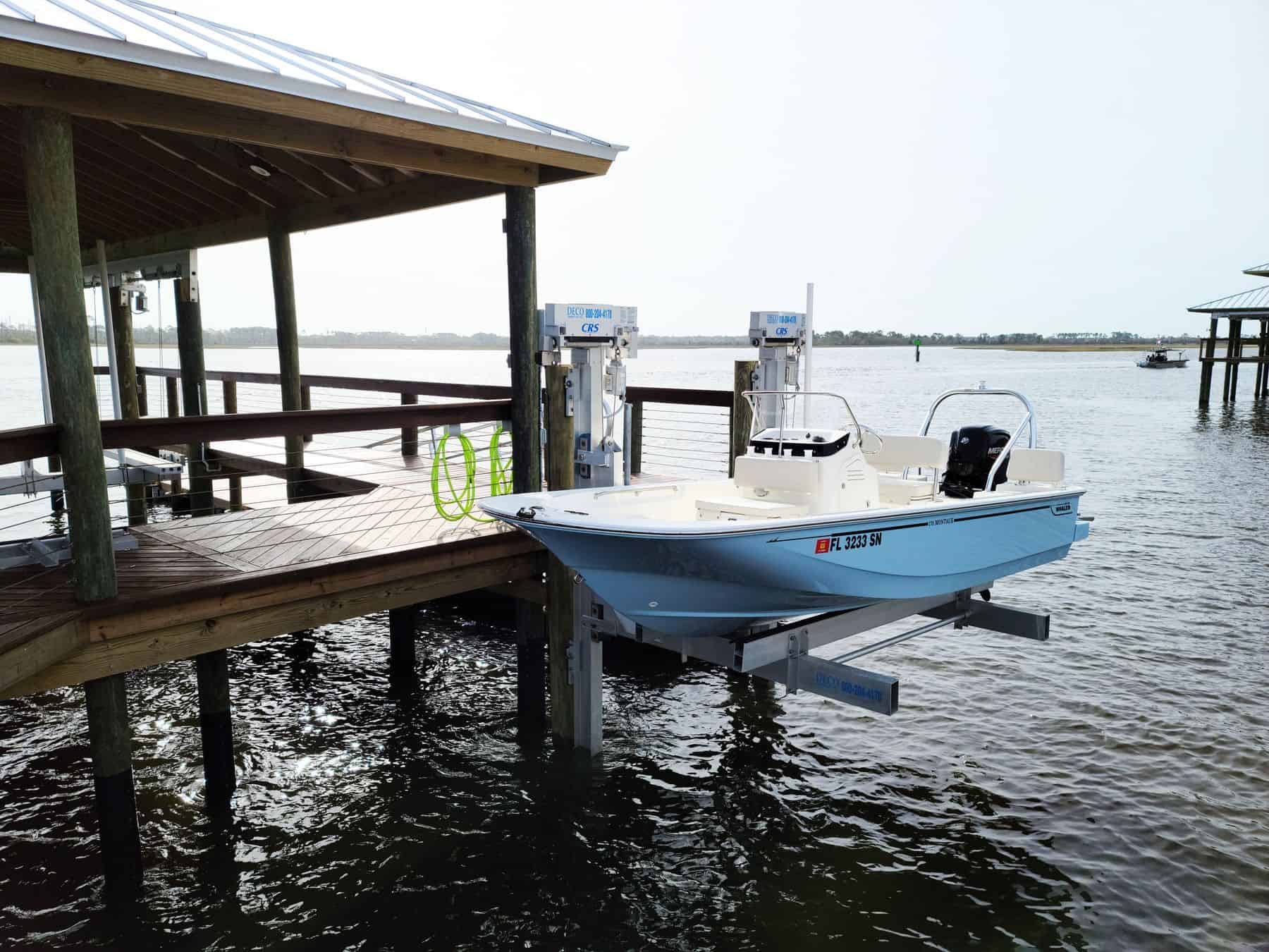 Covered boat lift holding a centre-console boat above the water