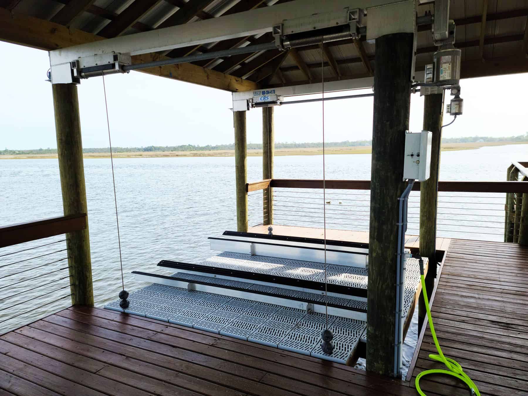 Boat lift mechanism and decking under a covered boathouse