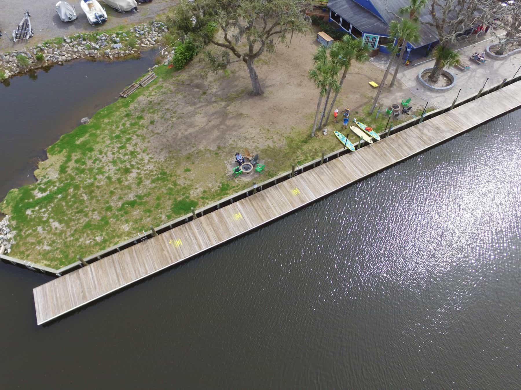 Aerial view of a dock and walkway following a lawn along the shoreline