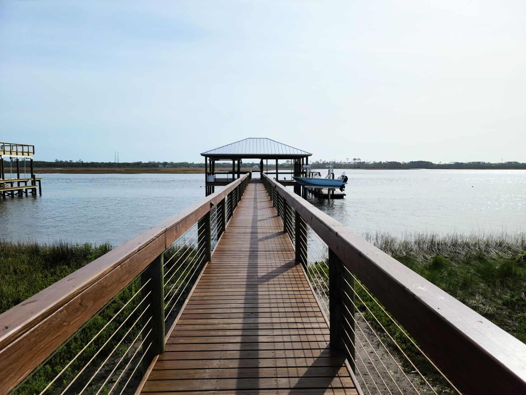 Timber walkway leading straight out to a covered dock over open water